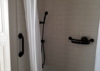 tile shower and custom window panels created by regional renovations in historical home bathroom renovation